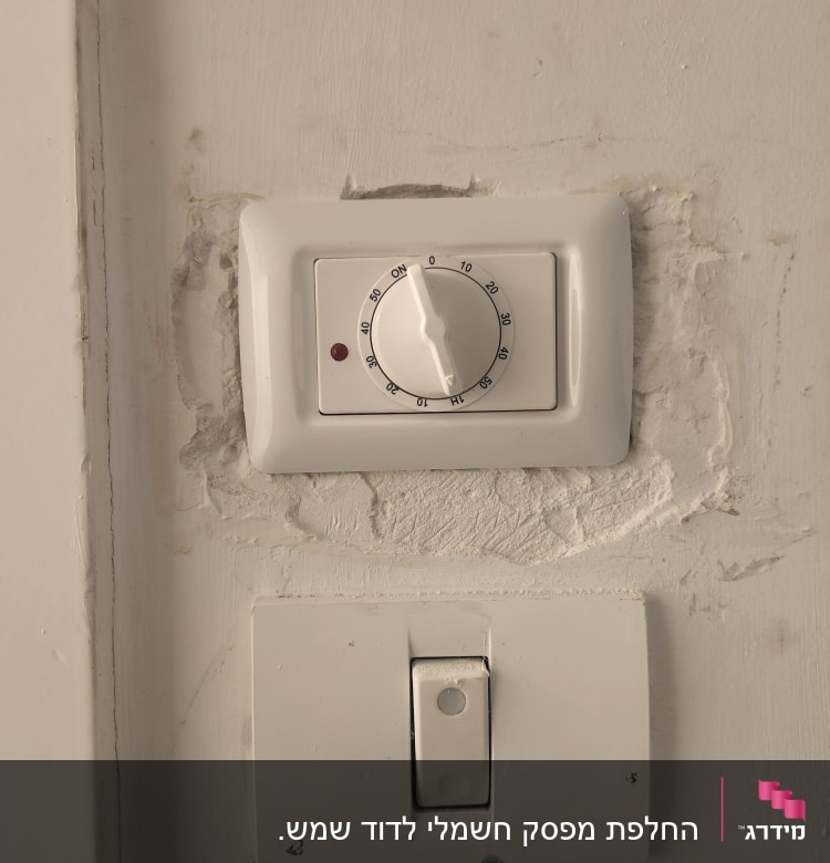 שני מתגים על קיר, אחד עם חוגה ואור אדום